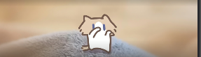 A simple line drawing of a cat-like character with closed eyes and a slight smile, set against a blurred background of a person on a beach.