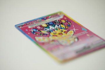 A blurred photograph of a holographic Pokémon trading card, specifically Mr. Mime, resting on a white surface.