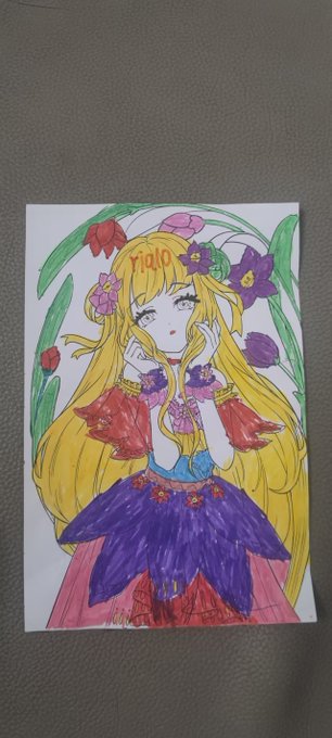 A child's hand-drawn colored illustration of an anime-style girl with long blonde hair, a purple and red dress, and flowers, with 'Viola' written in her hair.