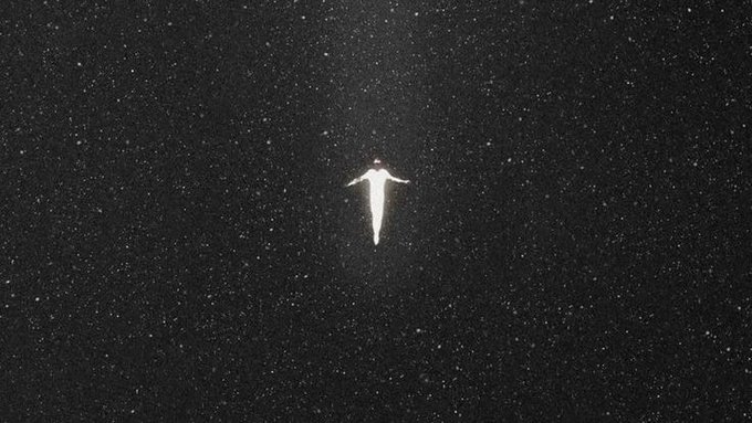In this image, a man wearing white stands in space among numerous stars above him. The sky is filled with countless stars, creating an atmosphere of vastness and mystery. There are no people or other objects visible within the frame. The relative position of the stars suggests that they might be part of a galaxy, possibly the Large Magellanic Clouds seen from Earth's perspective.