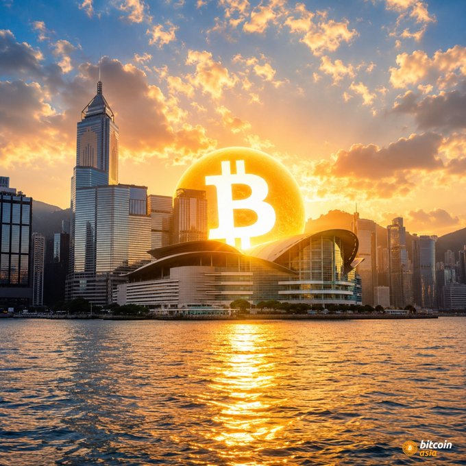 A Bitcoin promotional image showing the Bitcoin logo as a glowing sun over a modern city skyline at sunset, reflected in the water, branded 'bitcoin asia' in the corner.