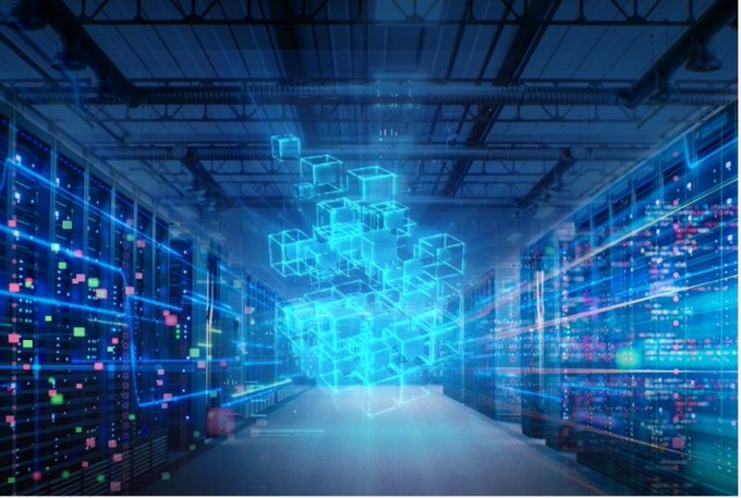 A futuristic data center with rows of server racks features a glowing blue holographic cube structure floating in the center aisle.