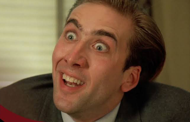 A close-up of actor Nicolas Cage with wide eyes and an exaggerated, manic expression, smiling broadly.