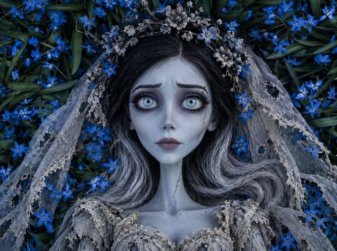 A gothic digital artwork of a pale, melancholic bride with cracked skin, dark eyes, and a tattered lace veil and dress, surrounded by a backdrop of vibrant blue flowers.