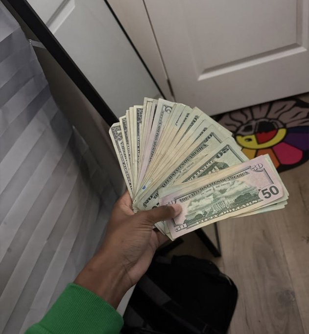 A hand fans out a stack of $50 bills, displaying the visible "50" denominations, visually embodying the caption's message that wealth is close at hand and far from poverty.