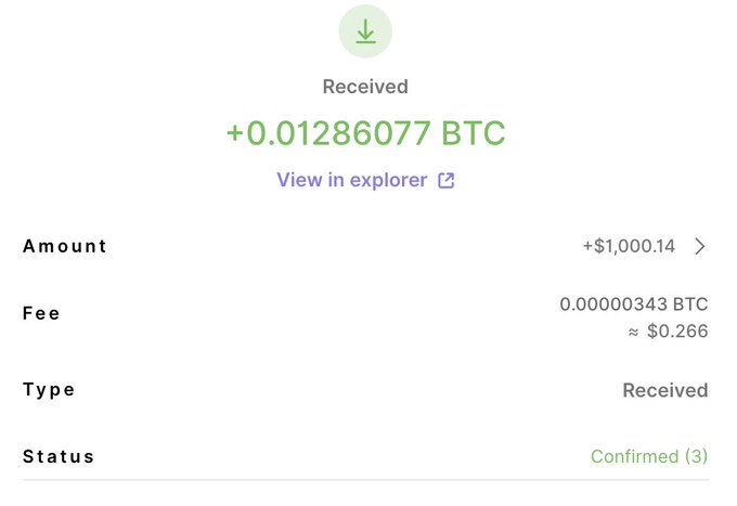 A cryptocurrency wallet confirmation screen showing a received transaction of +0.01286077 BTC (approximately +$1,000.14) with a confirmed status.