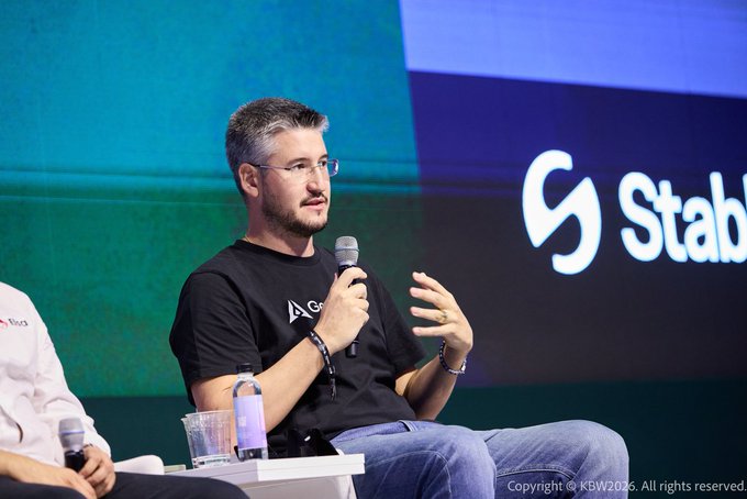 A man with glasses and a black t-shirt speaks into a microphone while seated on stage, with "Stable" and "S" logo visible in the background, and "Copyright @ KBW2026. All rights reserved" at the bottom right.