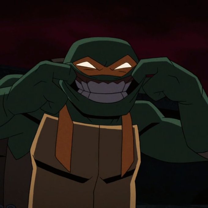 An animated illustration of a Teenage Mutant Ninja Turtle character wearing a green mask, grinning widely while pulling the mask down with both hands.
