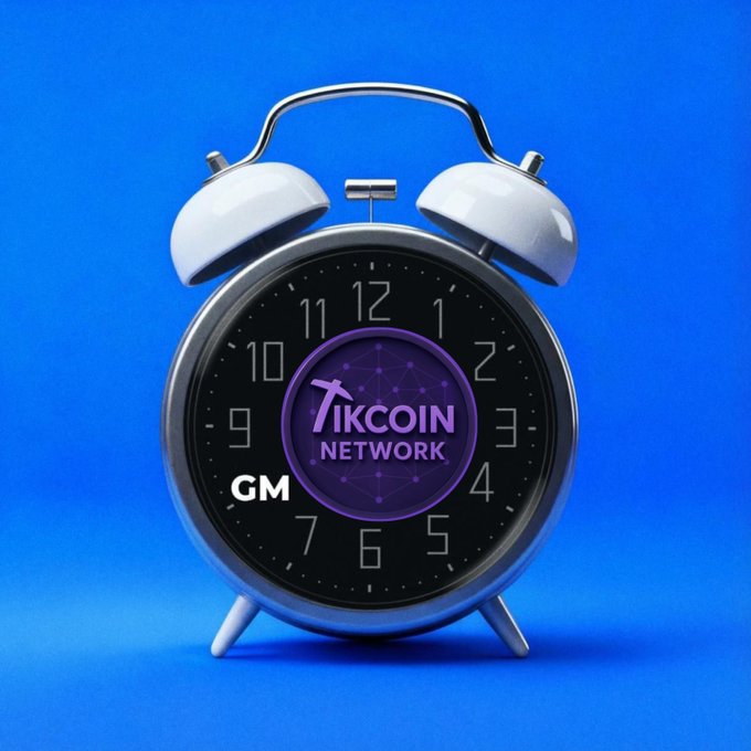 A silver twin-bell alarm clock against a blue background, with its face displaying the 'TIKCOIN NETWORK' logo and the time 'GM'.