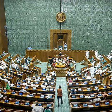 The image shows India's Parliament chamber with members seated at desks arranged in curved rows, while the accompanying post suggests that a parliamentary panel is likely to recommend stricter monitoring of crypto transactions and broader consultations on digital asset regulations. This setting indicates that the policy discussions on cryptocurrency oversight would be deliberated within this legislative body.