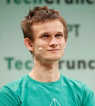 A photograph of Vitalik Buterin, the Ethereum co-founder, wearing a teal/green t-shirt with an earpiece microphone, appearing at a TechCrunch event.