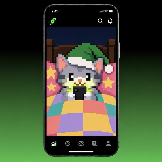 A smartphone screen displaying a pixel art game character—a gray cat in a green hat lying in bed under a colorful patchwork quilt on a Robinhood app interface.