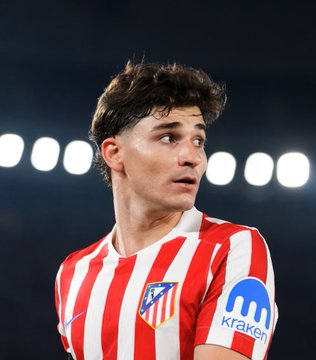 A young Atlético Madrid player in the club's iconic red and white striped kit, featuring the "Kraken" sponsor logo on the sleeve, is pictured during a match. The image ties to the post's mention of "La Liga football transfer drama before Atletico vs Malaga," visually anchoring the football portion of the otherwise crypto-focused update.