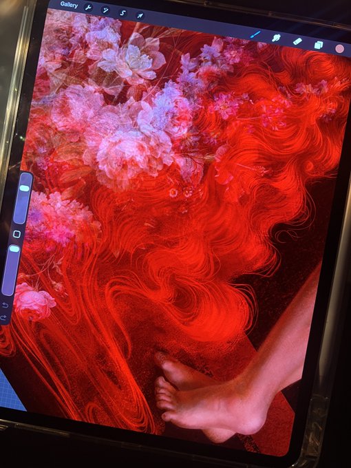 A digital drawing displayed on a tablet screen showing red hair swirling with flowers and a pair of feet against a red background.