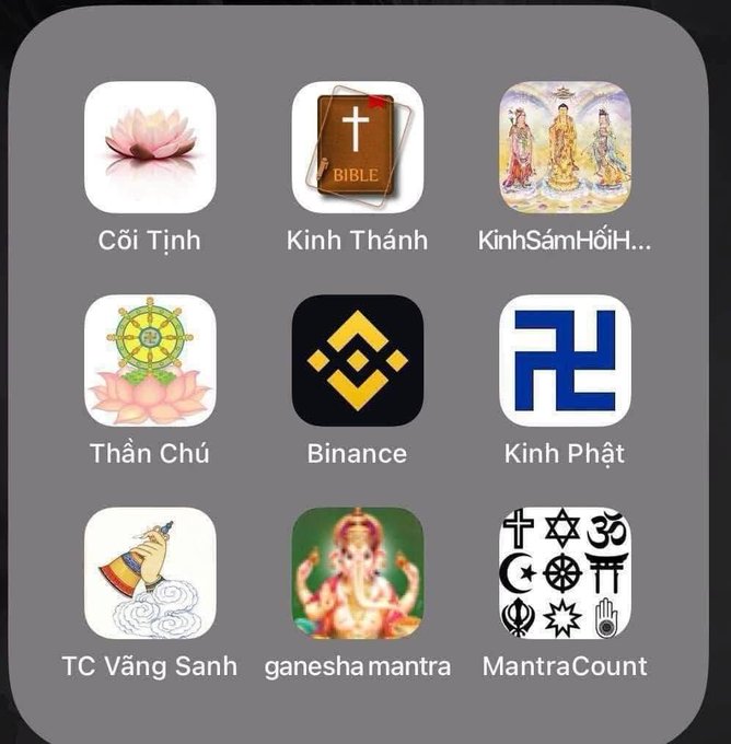 A smartphone home screen displaying various religious and spiritual app icons with labels like "Cõi Tịnh," "Kinh Thánh," "Kinh Sám Hối," "Thần Chú," "Binance," "Kinh Phật," "TC Vàng Sanh," "ganesha mantra," and "MantraCount."
