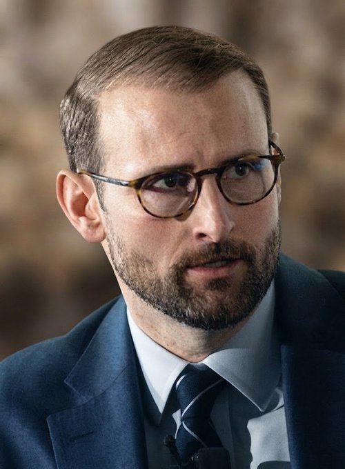 Patrick Witt, the White House crypto advisor, speaks during a television interview. The accompanying post quotes him criticizing banking industry concerns over deposit flight, arguing that deposits continued to grow despite stablecoin rewards and that the proposed Clarity Act contains yield caps and circuit breakers to address those concerns.