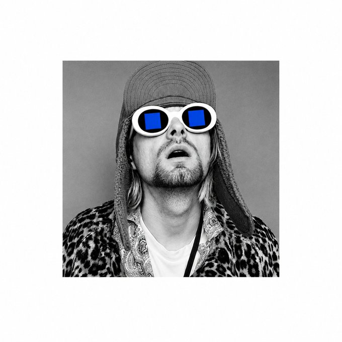 A black-and-white portrait shows a man in a backwards cap and leopard print shirt wearing sunglasses with blue reflective lenses.