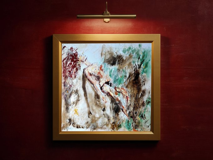 An abstract expressionist painting in a gold frame mounted on a deep red wall, featuring chaotic strokes of white, green, brown, and red, illuminated by a brass picture light above.