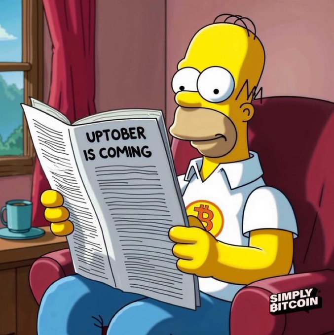 An image styled like a Simpsons cartoon showing Homer Simpson reading a newspaper with the text "UPTOBER IS COMING", wearing a shirt with a Bitcoin logo, and a "SIMPLY BITCOIN" watermark in the corner.