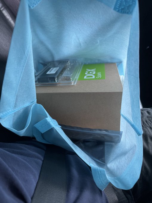 A DGX Spark box, likely containing a Sparkly cleaning product based on the green label, sits inside a light blue tote bag placed on a car seat, ready for purchase. The image humorously contrasts the post's intent to "buy 3 more DGX Sparks," as DGX is also a well-known ticker symbol, suggesting a playful play on the ticker vs. the actual product.