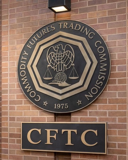 A bronze and black plaque on a brick wall displays the seal and name of the "COMMODITY FUTURES TRADING COMMISSION," with "CFTC" on a separate sign below.