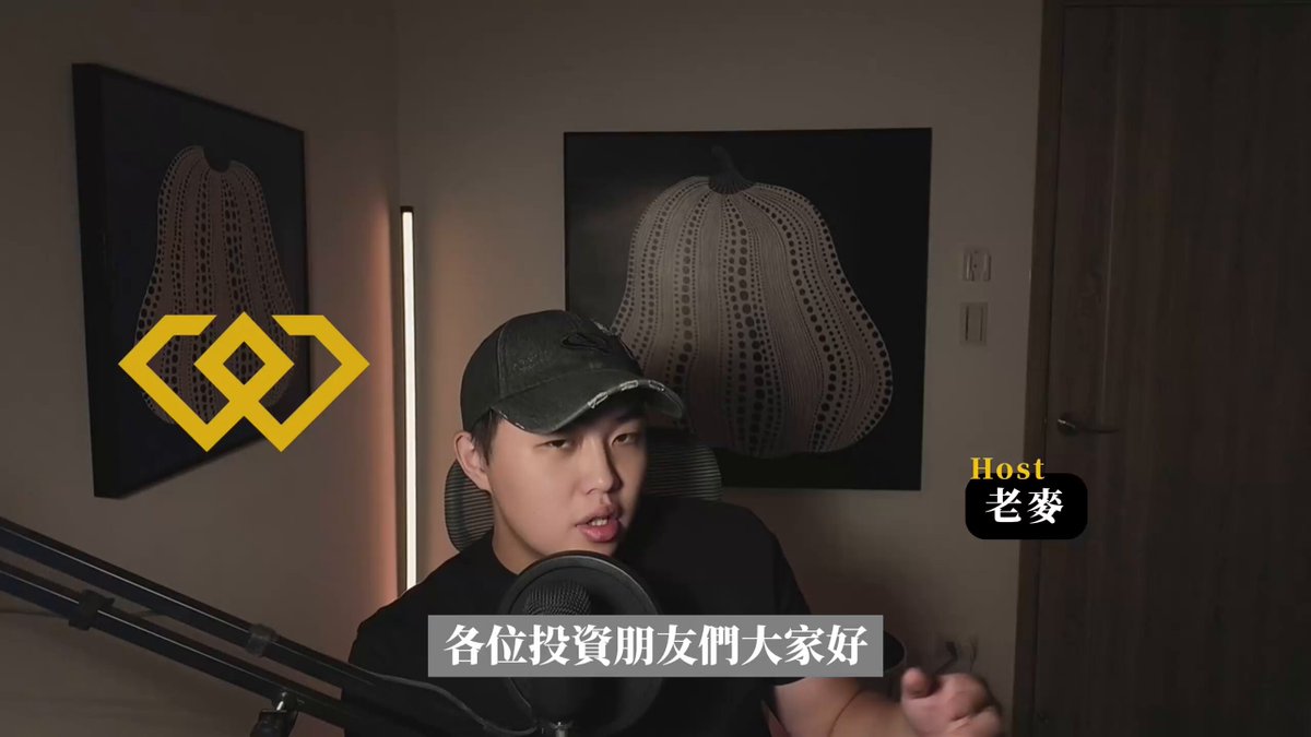 The image features a man wearing a black baseball cap, sitting behind a microphone with headphones on his head. The caption of the image reads "#富途、#老虎 被重锤 你的资产该何去何从？ 美股要凉？加密要崩？ 还是波动越大，翻盘机会越大", which suggests that the man is a professional musician or performer. The image also includes text in Chinese, indicating that it was taken at an event with international attendees.
