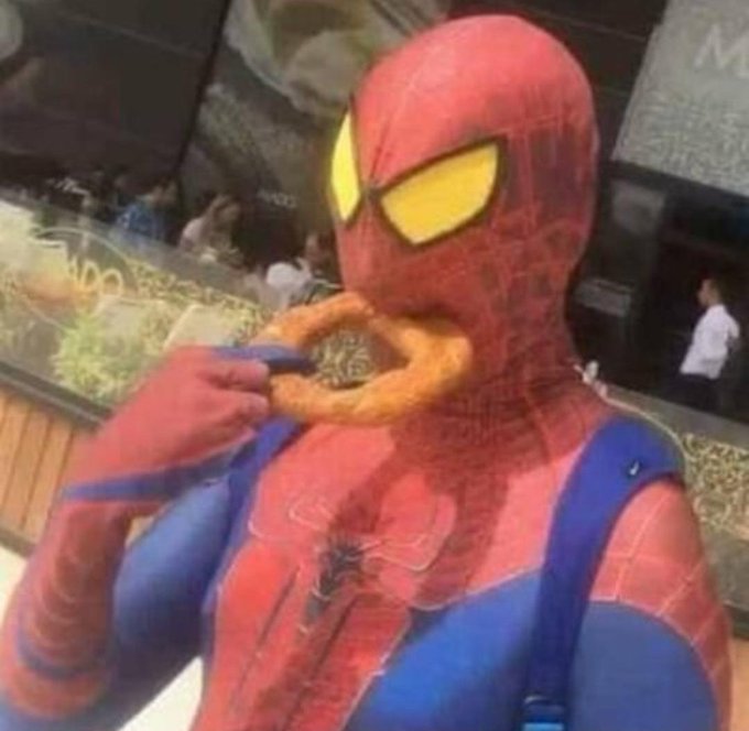A person in a Spider-Man costume takes a bite out of an onion ring, humorously mimicking his own iconic mask in a McDonald's setting. The image playfully relates to the post about USD* APY rising above 10%, suggesting investors are "hungry" for the high-yield opportunity, just like Spider-Man is for the snack.