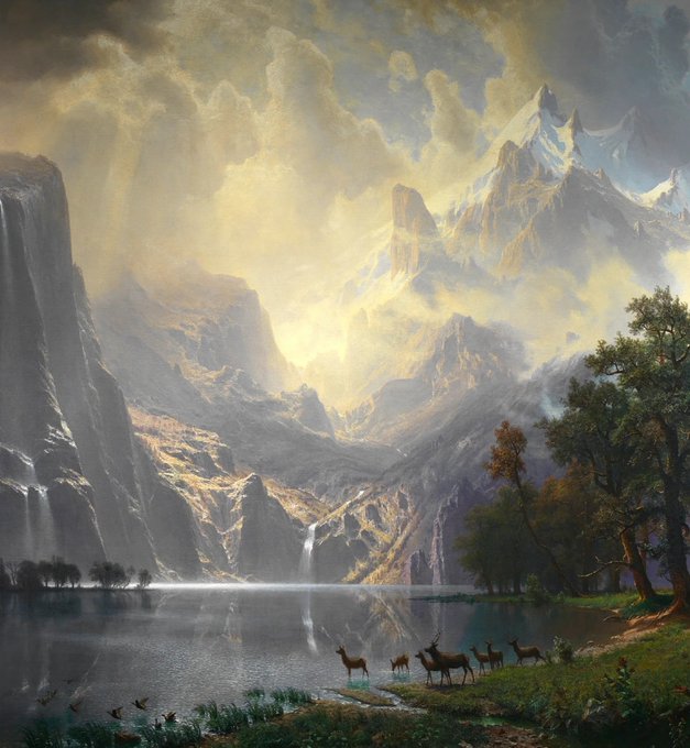 A romantic landscape painting in the style of Albert Bierstadt, depicting towering, sunlit mountains, a calm reflective lake, a cascading waterfall, and a group of deer grazing in the foreground.