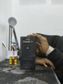A small, low-resolution thumbnail shows a person in a suit working at a desk with a smartphone mounted on a tripod.