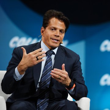 The image features a man wearing a suit and tie sitting down while talking. The background of the image shows a blue wall with white text that reads "LATEST: Anthony Scaramucci says the four-year Bitcoin cycle is still alive and BTC will re-ascend in Q4, calling ... this time is different." This suggests that the man might be discussing the current state of Bitcoin or cryptocurrency markets. The post also mentions a four-year Bitcoin cycle, which could imply that the man is referring to historical trends or patterns in the market.