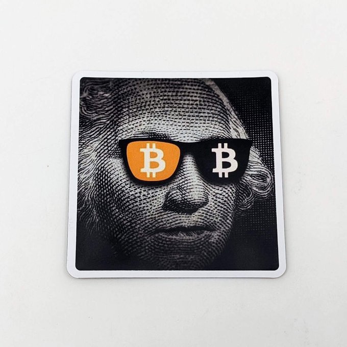 A sticker featuring a portrait of George Washington wearing sunglasses with the Bitcoin (₿) logo on the lenses.