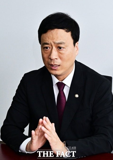 A man in a dark suit and burgundy tie sits at a table with his hands clasped, appearing to be in an interview or discussion setting. The image bears a "THE FACT" watermark and shows the politician Jeong Seong-guk, a member of the People Power Party, who is associated with the accompanying post about his proposal to defer virtual asset taxation to January 2030.