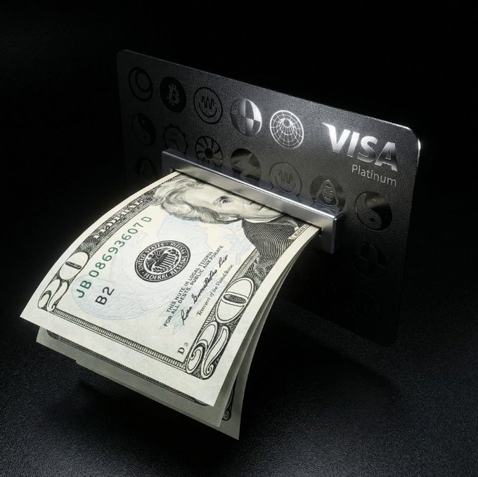 The image features a stack of US dollar bills being inserted into an ATM or similar machine. The money is neatly folded and pushed down against the side of the card reader, indicating that someone has recently used the ATM for transactions. The scene suggests that the user may be spending their cash from the $TRIA account at useTria, as indicated by the post's description.