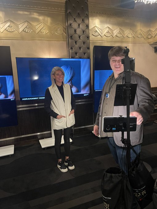 A woman named Abraham Modl poses next to a smiling man operating an INTEL RealSense 3D camera setup at a tech display booth.