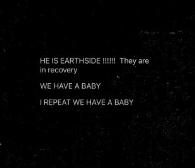 A black screen with white text reading: "HE IS EARTHSIDE !!!!!!! They are in recovery / WE HAVE A BABY / I REPEAT WE HAVE A BABY."