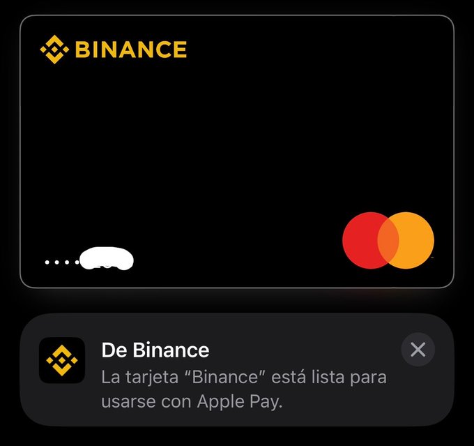 A digital Binance Mastercard notification appears on an iPhone screen, showing the message "De Binance: La tarjeta 'Binance' está lista para usarse con Apple Pay." This aligns with the post announcing the new Binance card's availability for use with Apple Pay.