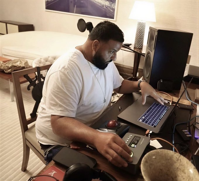 A bearded man in a white t-shirt works intensely on a laptop in a hotel-style room, surrounded by audio equipment including studio monitors, a microphone, and what appears to be an audio interface.

The image humorously illustrates the post by suggesting the man is so focused on music production and studio work that he hasn't had time to track or trade crypto coins this week.