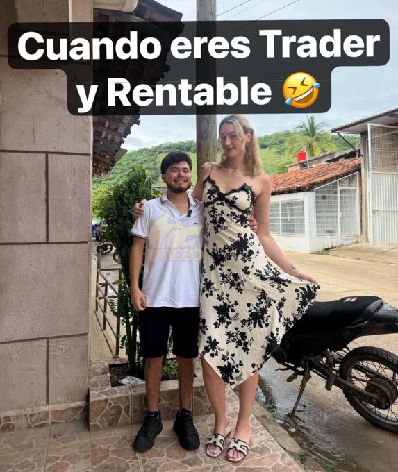 A photo of a short man standing next to a very tall blonde woman in a floral dress, with Spanish text reading "Cuando eres Trader y Rentable 🤣" (When you are a profitable trader), referencing the height difference humorously.