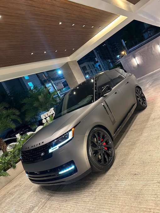 A matte black Range Rover with custom black wheels and red brake calipers is parked at what appears to be a hotel entrance at night. The luxurious SUV complements the post's message about building for tomorrow, though the specific "GM CT" branding and personalized connection to the vehicle owner isn't visually confirmed in the image itself.