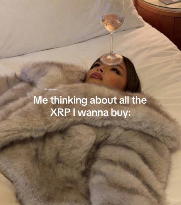 A woman lies in bed under a fuzzy gray blanket with an empty wine glass balanced on her forehead, captioned 'Me thinking about all the XRP I wanna buy' with the handle @mybvibe.