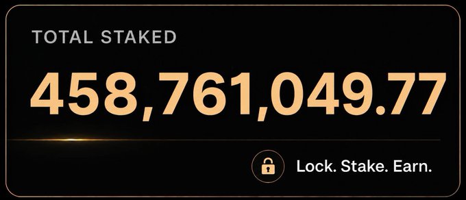 A digital display showing 'TOTAL STAKED' at 458,761,049.77 with the tagline 'Lock. Stake. Earn.' featuring a padlock icon.