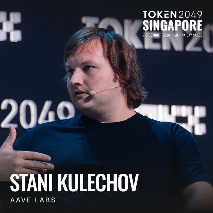 Stani Kulechov, founder and CEO of Aave Labs, speaks at TOKEN2049 Singapore (October 7-8, 2026, Marina Bay Sands), pictured wearing a black t-shirt and headset microphone while addressing the audience on stage.