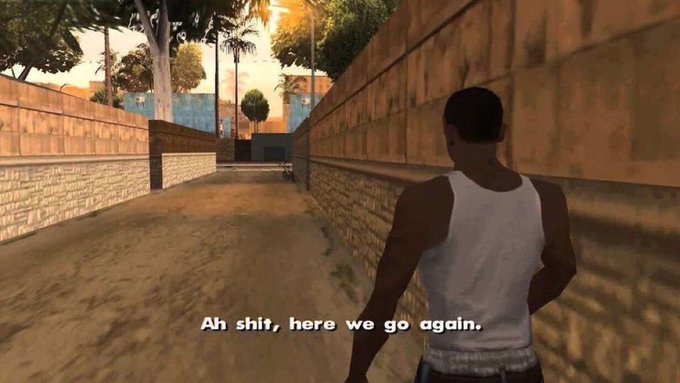 A screenshot from the video game Grand Theft Auto: San Andreas showing the protagonist CJ in a white tank top in an alleyway, with the subtitle 'Ah shit, here we go again.'