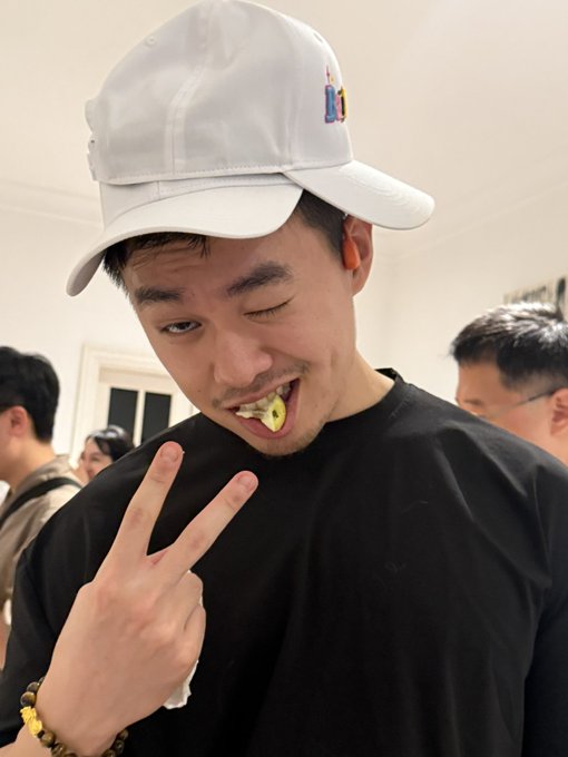 Image 10: The image shows a young man with a white cap making a peace sign while eating.