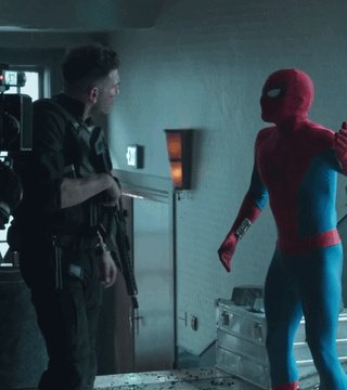 A man in a Spiderman costume stands next to a man wearing black clothing, engaging in an intense argument over their responsibility for a price increase. They both seem to be fighting or trying to assert dominance over each other as they stand near boxes on what appears to be a store floor. The text "Red triangles arguing about who’s to blame for $avax price" is present near the image, further emphasizing that this scene is related to an online shopping discussion or disagreement between two individuals.