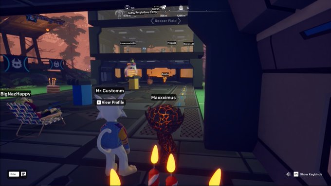 A screenshot from a multiplayer virtual game (Soccer Field) showing cartoon avatars named BigNazHappy, Mr.Customm, and Maxximus, with candles in the foreground and a lounge chair area visible.