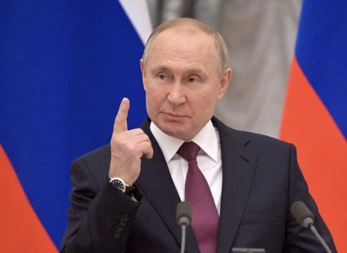 Russian President Vladimir Putin points his finger upwards, in front of the Russian flag, on the same day Russia's State Duma legalized Bitcoin and crypto for international trade as property.