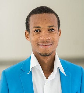 A young man in a vibrant blue blazer and white shirt smiles at the camera in a portrait-style photo, with no text visible in the image. The accompanying post appears to promote $NRED stock, tying the image's professional appearance to themes of investment and emerging market opportunities.