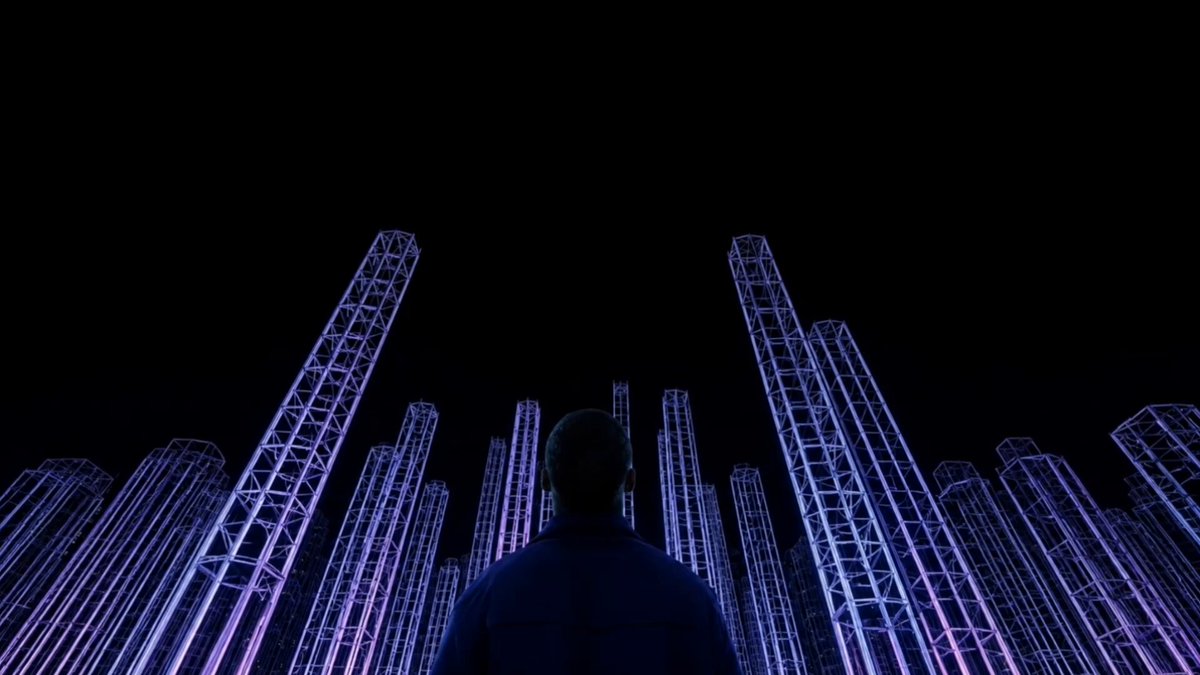 The image shows a man standing in front of a large number of tall structures with purple lights at the top. The man appears to be looking up towards these structures, which are likely part of an art installation or a futuristic cityscape. The caption above the image provides information about the market structure and how it has evolved over time.