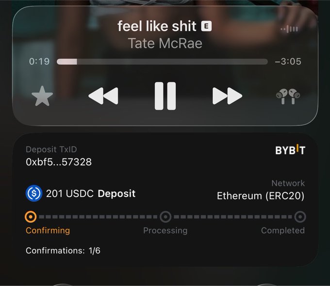A screenshot shows a music player playing "feel like shit" by Tate McRae, alongside a Bybit exchange notification confirming a 201 USDC deposit on the Ethereum (ERC20) network with transaction ID 0xbf5...57328 still in the "Confirming" stage (1/6 confirmations). The image humorously juxtaposes the melancholic song title with the user's excitement over winning crypto earnings, likely as a result of following the giveaway winner @cryptojourneyrs mentioned in the post.
